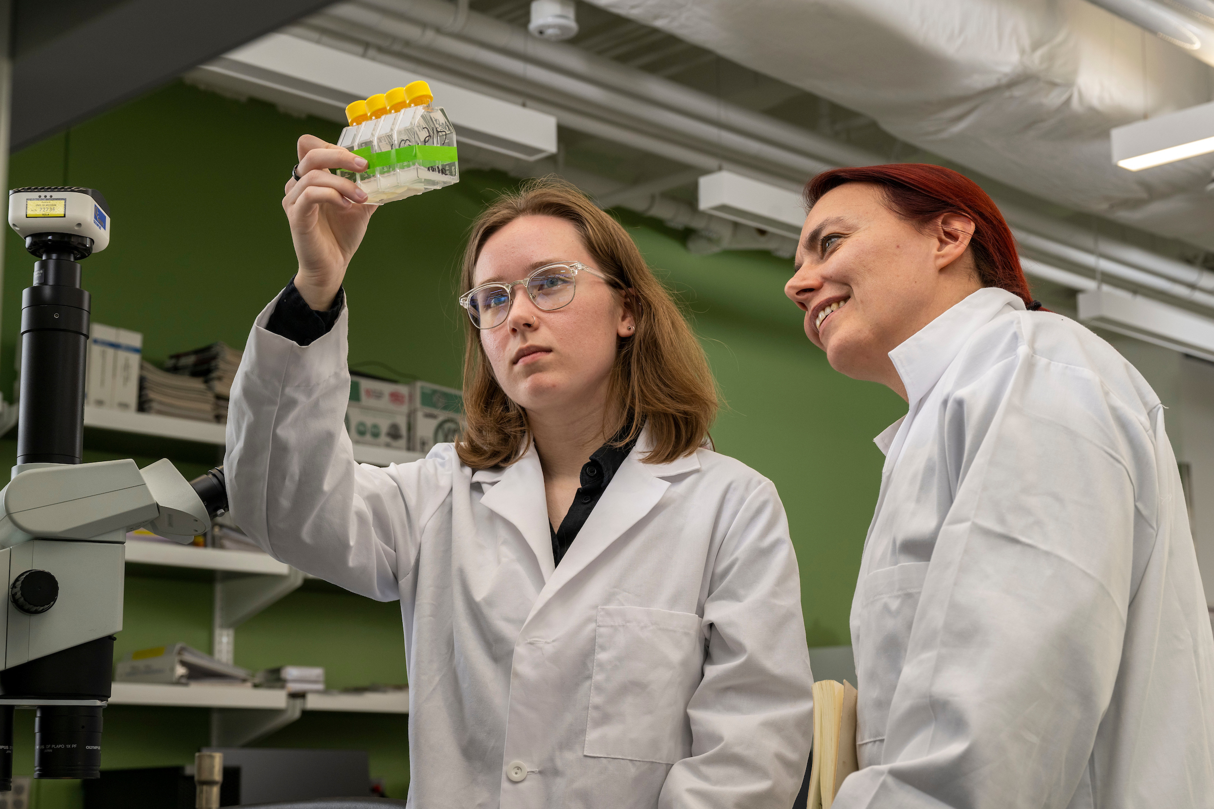 Biology student and instructor in lab